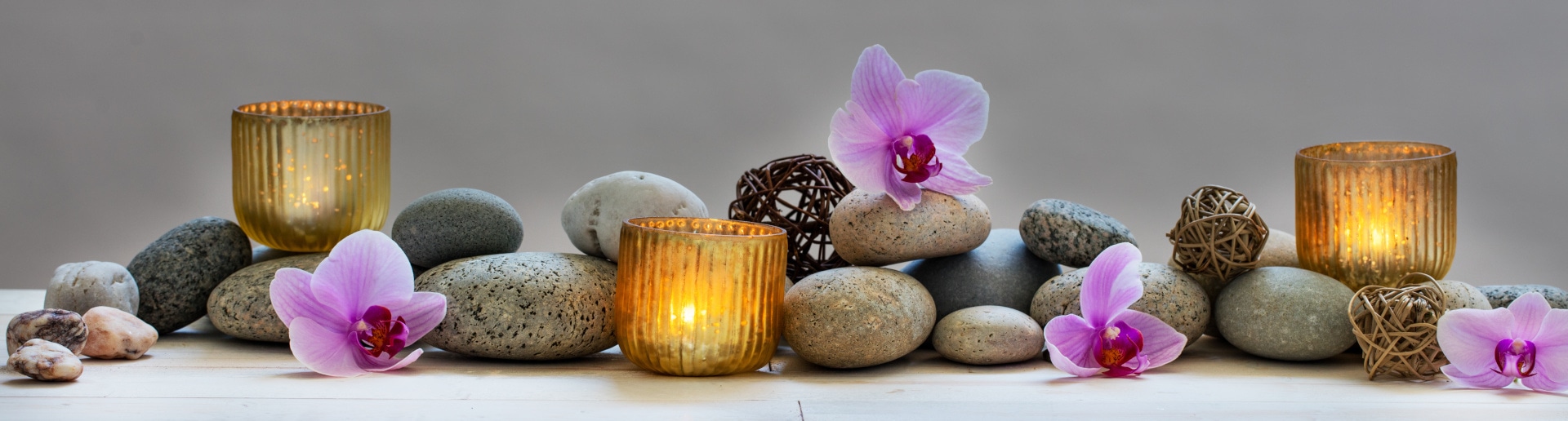 Concept of wellbeing with pebbles, orchids and candles, panorami
