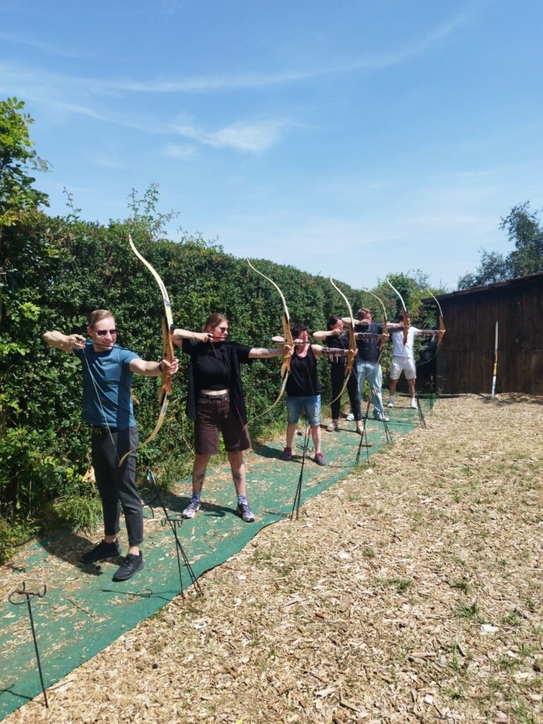 Sechs Teammitglieder von RegioHelden mit Bogen in der Hand im Freizeitpark Rutesheim.